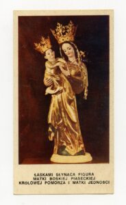 Obrazek dewocyjny przedstawiający rzeźbę Matki Boskiej z Dzieciątkiem. Kobieta trzyma małe dziecko na prawym ramieniu. Twarze uśmiechnięte, szaty i korony złote. Białe passe-partout, na dole napis: „Łaskami słynąca figura Matki Boskiej Piaseckiej Królowej Pomorza i Matki Jedności.”
