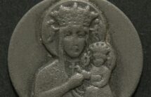 Fotografia okrągłego medalika z wizerunkiem Matki Boskiej z Dzieciątkiem, barwa srebrna.