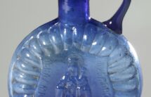 09. Fotografia butelki na wodę święconą z niebieskiego szkła z wizerunkiem Matki Boskiej z Dzieciątkiem.