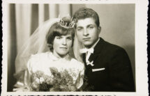 Fotografia czarno-biała młodej pary, Panna Młoda z bukietem goździków