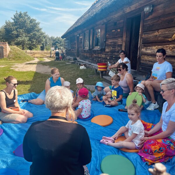 Dzieci i dorośli na kocach w skansenie
