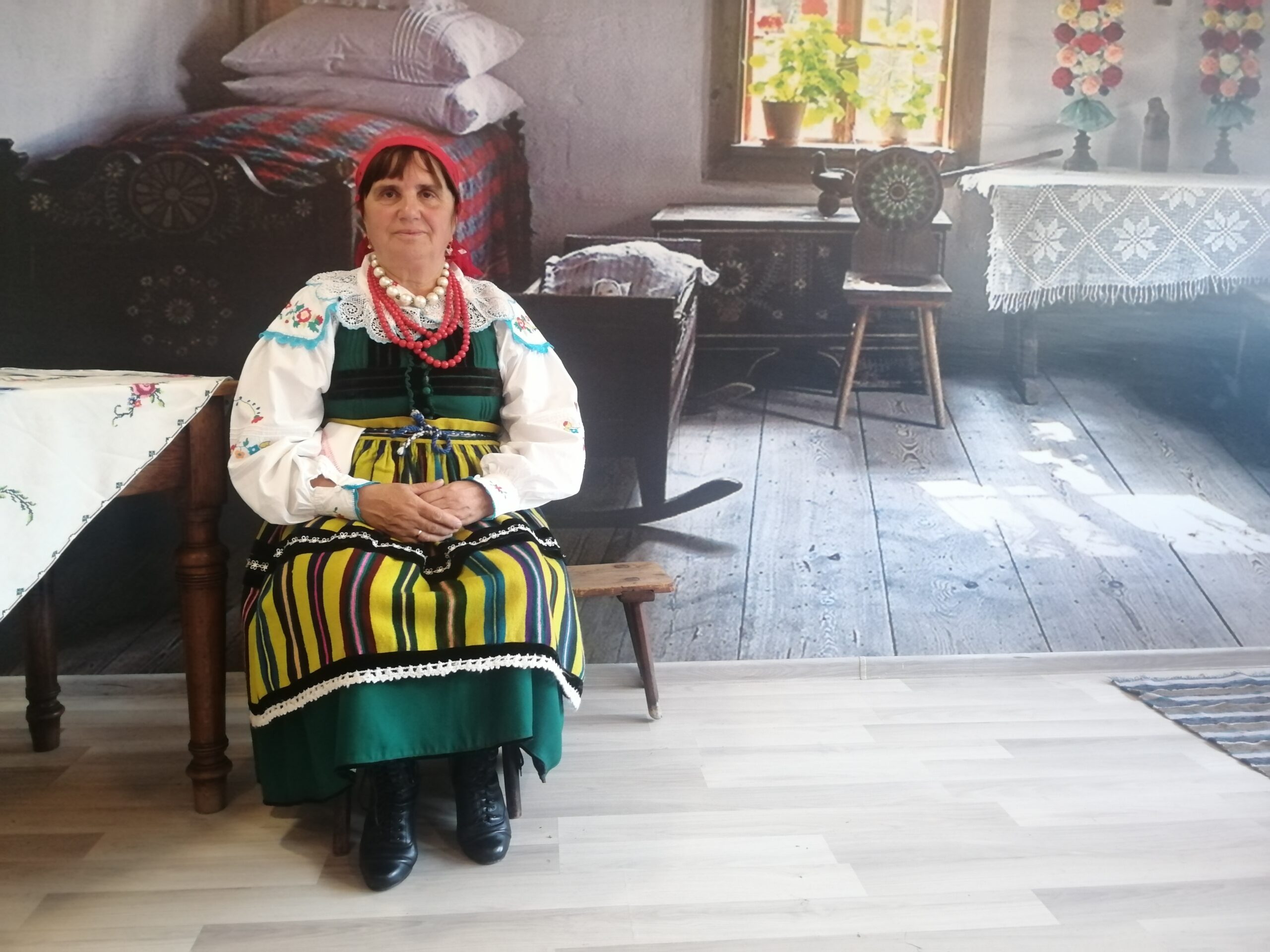 Kobieta w ludowym stroju w starej chałupie w skansenie