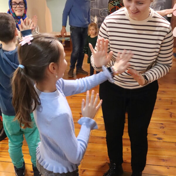 Kobieta i dziewczynka klaszczą naprzemiennie w swoje dłonie 