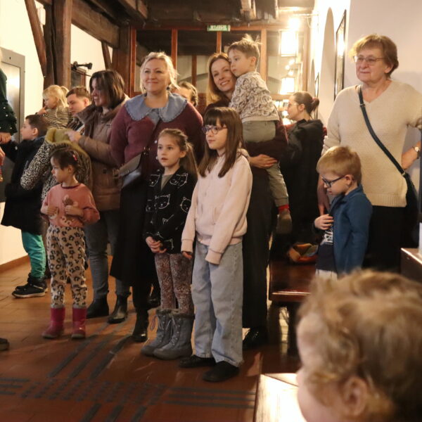 Rodziny z małymi dziećmi zebrane w hallu muzeum. 