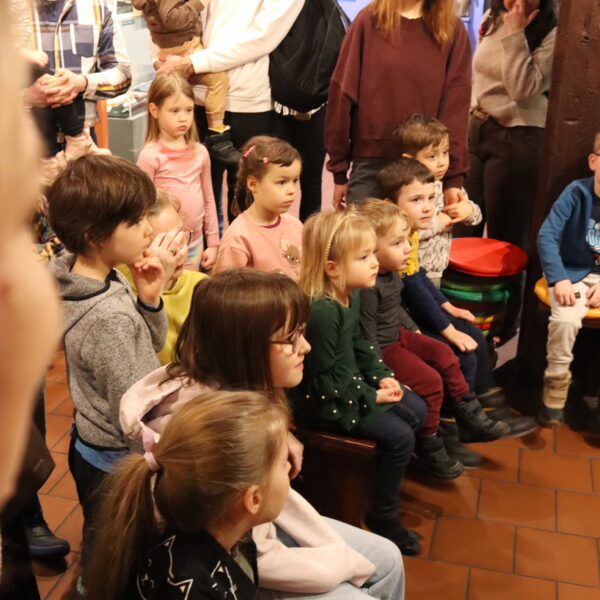 Rodziny z małymi dziećmi zebrane w sali muzeum 