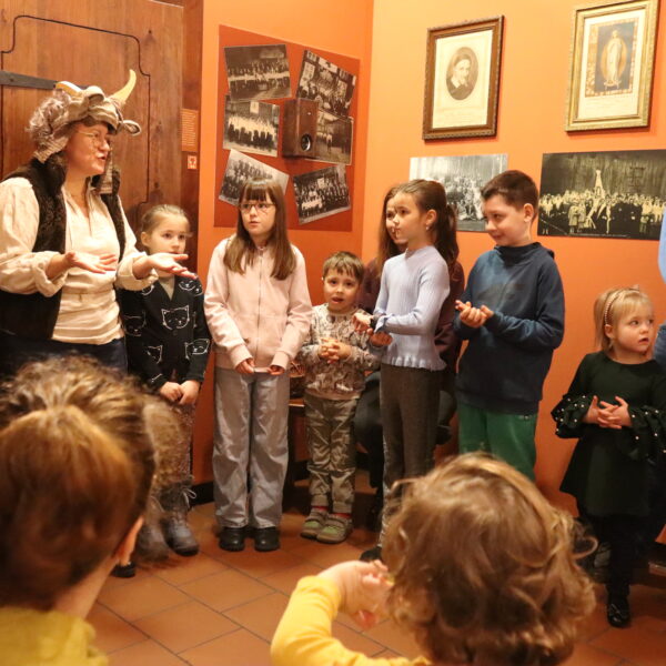 Rodziny z małymi dziećmi zebrane w sali muzeum 