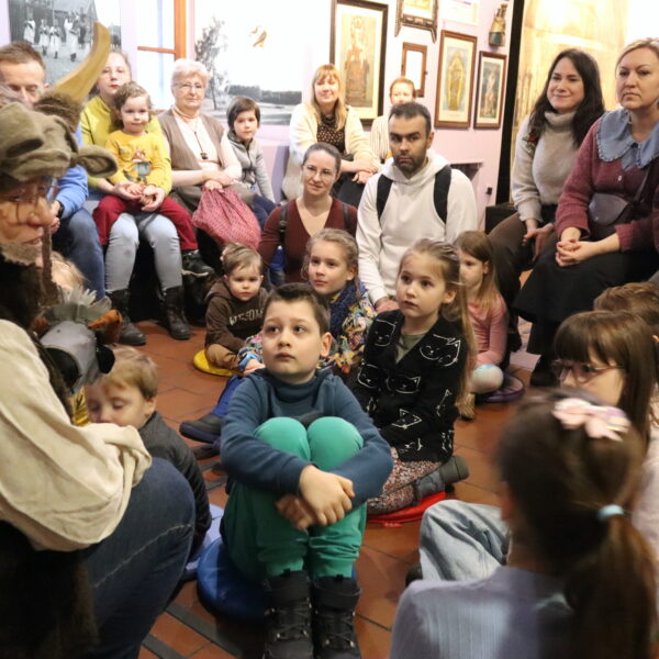 Rodziny z małymi dziećmi zebrane w sali muzeum 