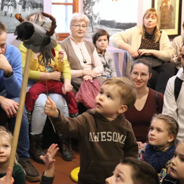 Rodziny z małymi dziećmi zebrane w sali muzeum 