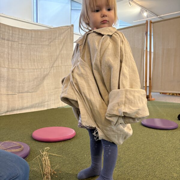 Dziewczynka w przydużej lnianej koszuli. 