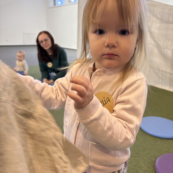 Dziewczynka trzyma w ręce lnianą koszulę 