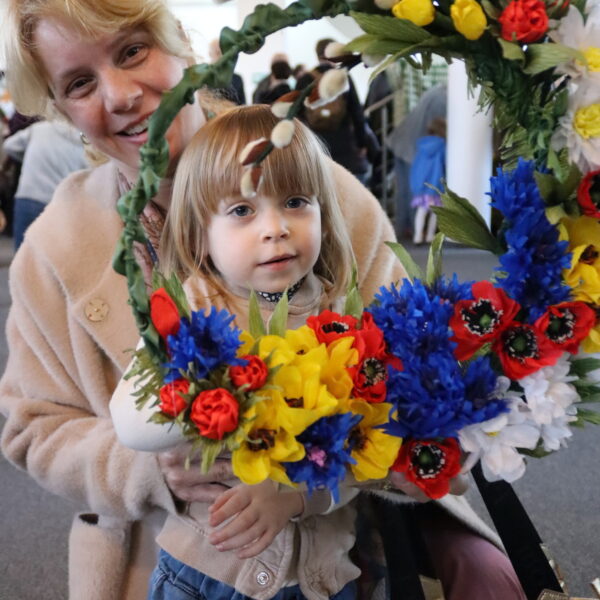 Kobieta i dziewczynka trzymają wianek. 