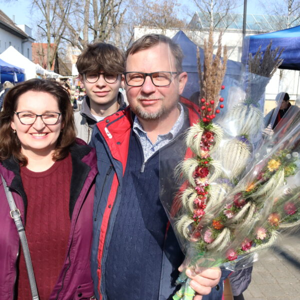 Rodzina (kobieta, mężczyzna, nastolatek) z palmami wielkanocnymi 
