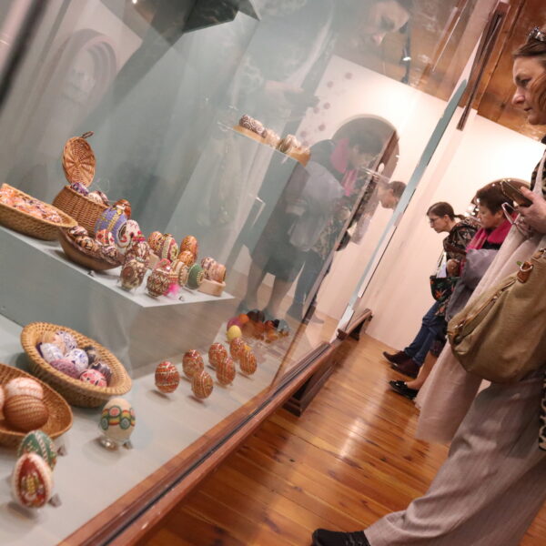 Ludzie oglądają wystawę pisanek. 