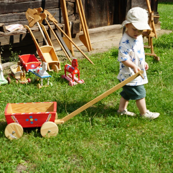 Dziecko z drewnianym wózkiem