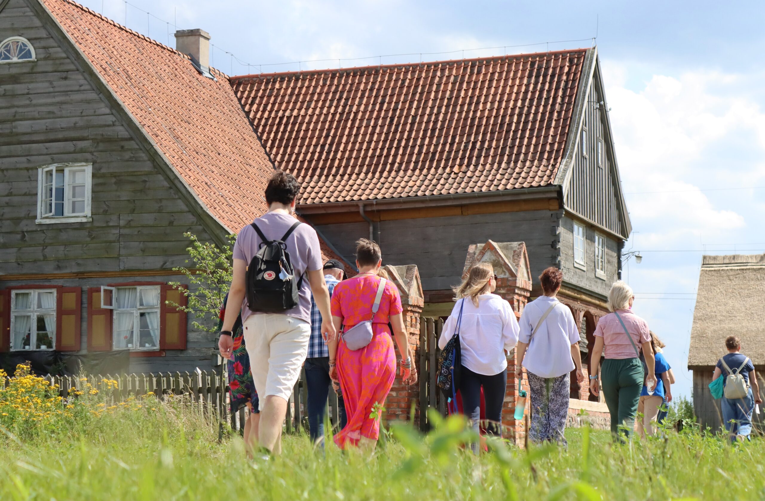 Turyści idą w stronę domu podcieniowego