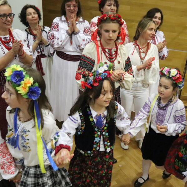 Ludzie w ludowych strojach tańczą na scenie 