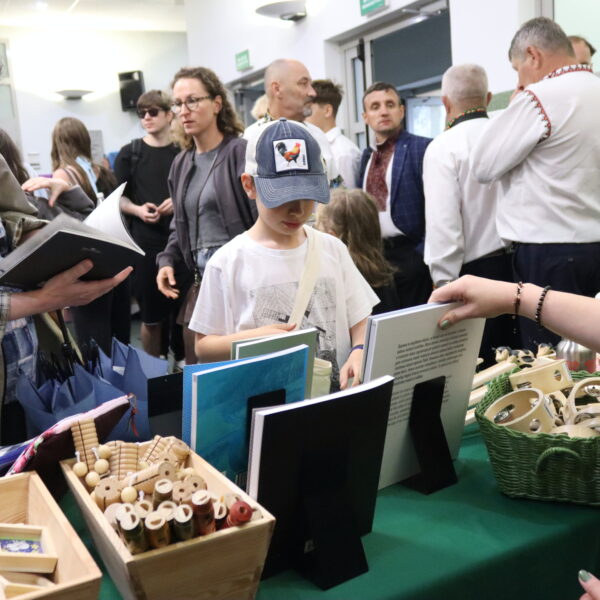 Ludzie przy stoisku z książkami i gadżetami 